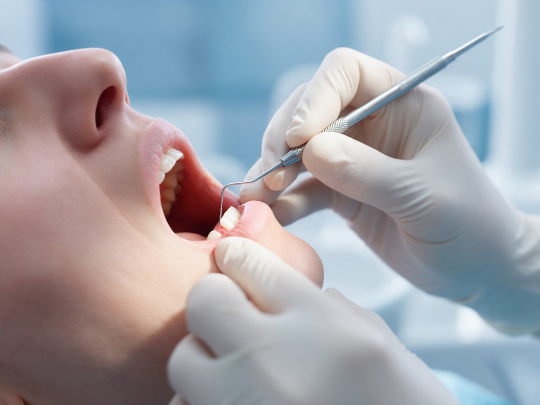 Exame periodontal com sonda em consultório odontológico